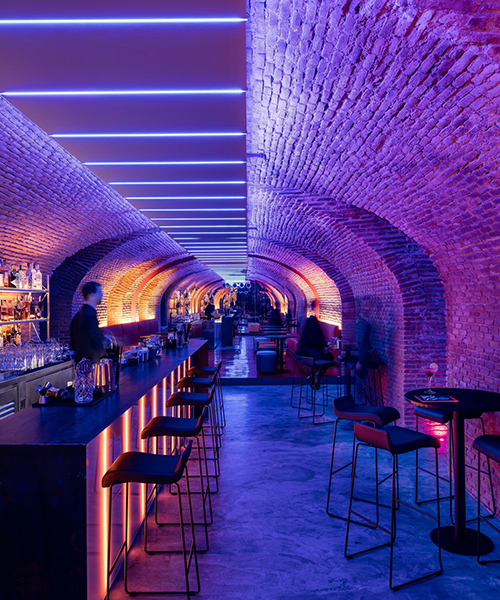 the cavernous, glowing 'bala perdida club' is hidden beneath streets of madrid