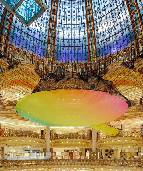 suspended rainbow playground stretches under the iconic dome of galeries lafayette in paris