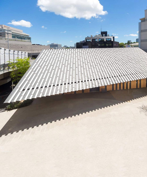 kengo kuma tops buddhist temple in tokyo with half-cylinder aluminum tiles
