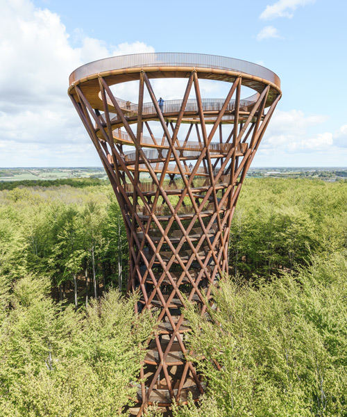 spiraling observation tower by EFFEKT soars above the trees of a danish forest