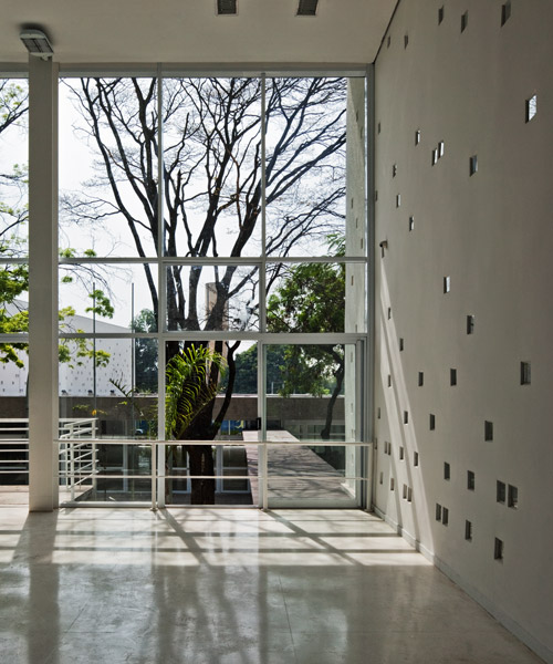 carolina penna architects designs a training center around existing trees in brazil