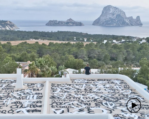 artist phil akashi spray paints homer’s odyssey onto a rooftop in ibiza