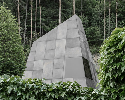 wine cellar in northern italy emerges from the ground with stone-like geometry