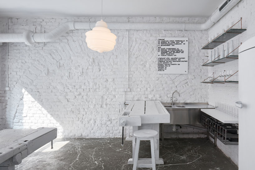 painted entirely white, this prague wine bar recalls a vintage artist studio