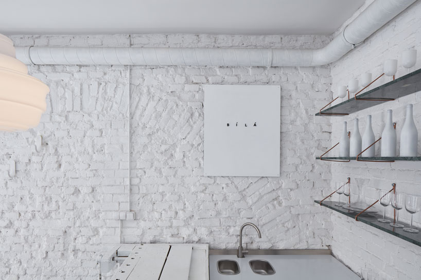 painted entirely white, this prague wine bar recalls a vintage artist studio