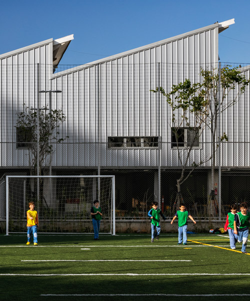 andrade morettin arquitectos + GOAA repurpose industrial sheds into beacon school in brazil