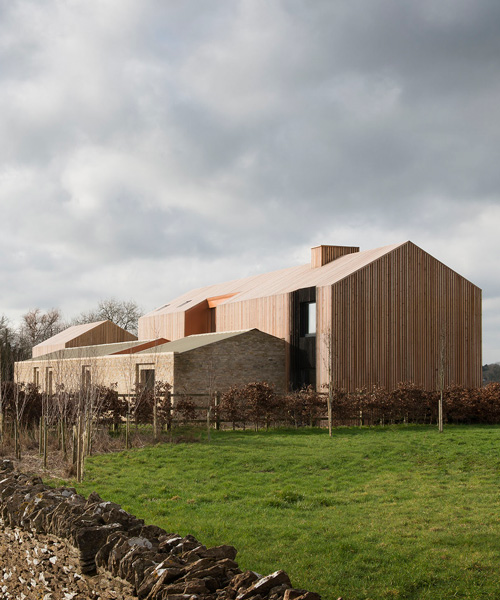 bureau de change combines interlocking barn volumes for house in rural england