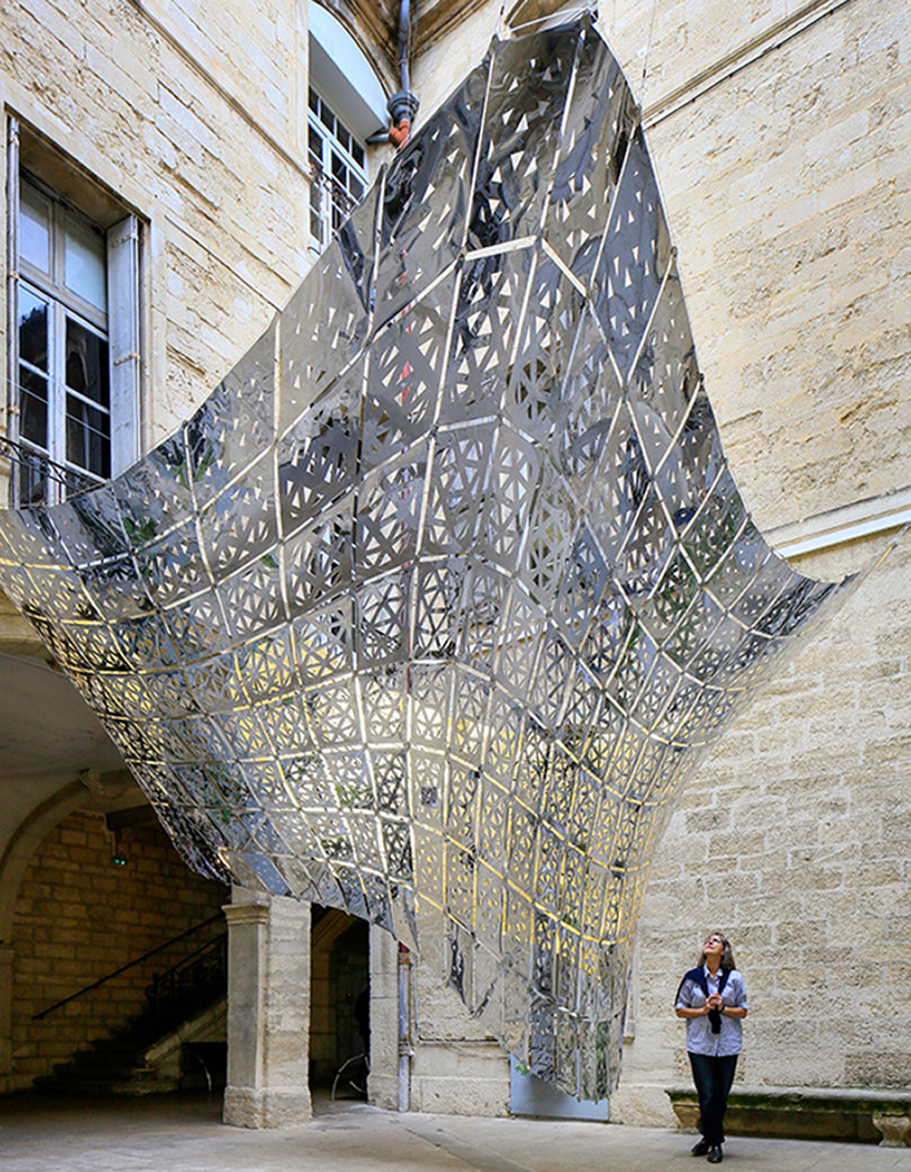designers suspend parametric golden butterfly within a historic courtyard in montpellier