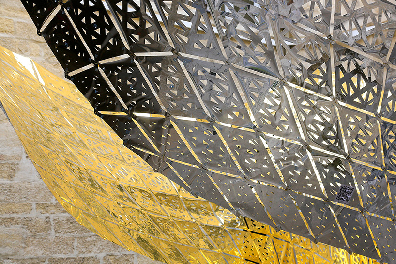 designers suspend parametric golden butterfly within a historic courtyard in montpellier