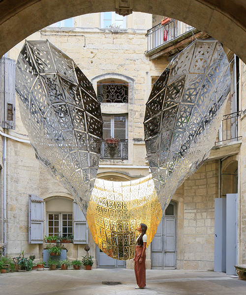 designers suspend parametric golden butterfly within a historic courtyard in montpellier