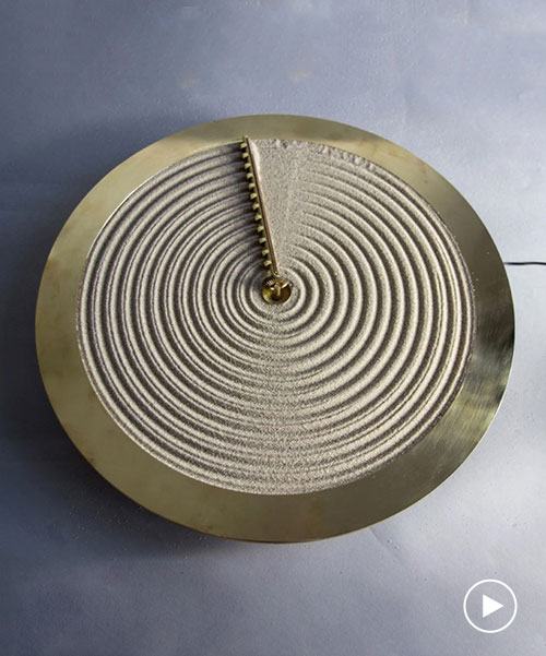 studio ayaskan's zen garden clock rakes sand to illustrate the passing of time