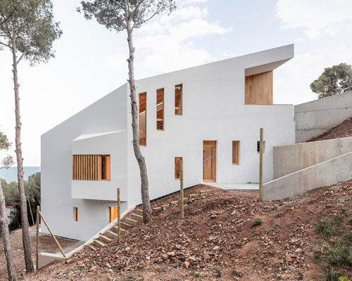 05 AM arquitectura's mediterranean house cascades down a steep slope in tamariu, spain