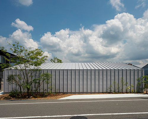arbol design wraps a riverside house in metal cladding in kawachinagano, japan
