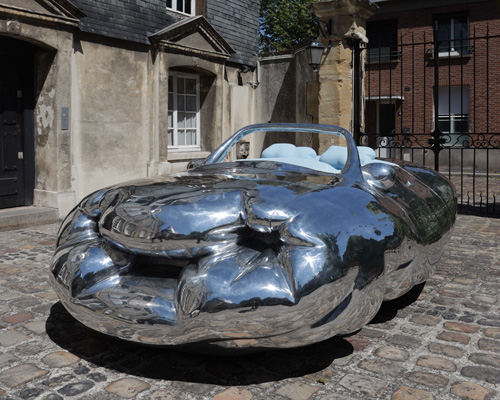 erwin wurm parks his fat car, narrow house, and big coat across the french city of le havre