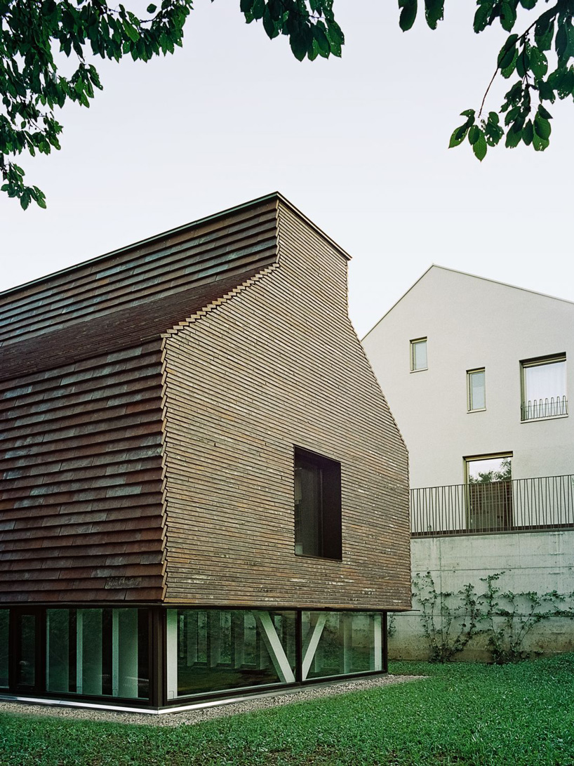stocker lee architteti clads office building in switzerland in rust-red tiles + bricks