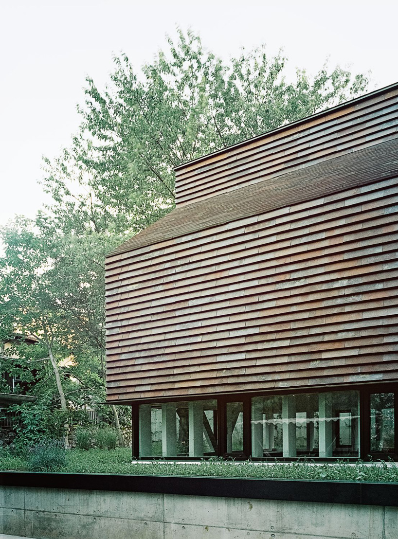 stocker lee architteti clads office building in switzerland in rust-red tiles + bricks