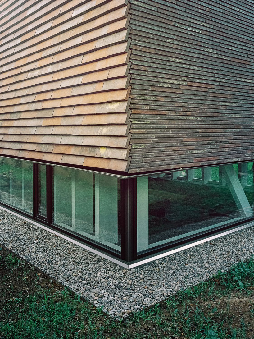 stocker lee architteti clads office building in switzerland in rust-red tiles + bricks