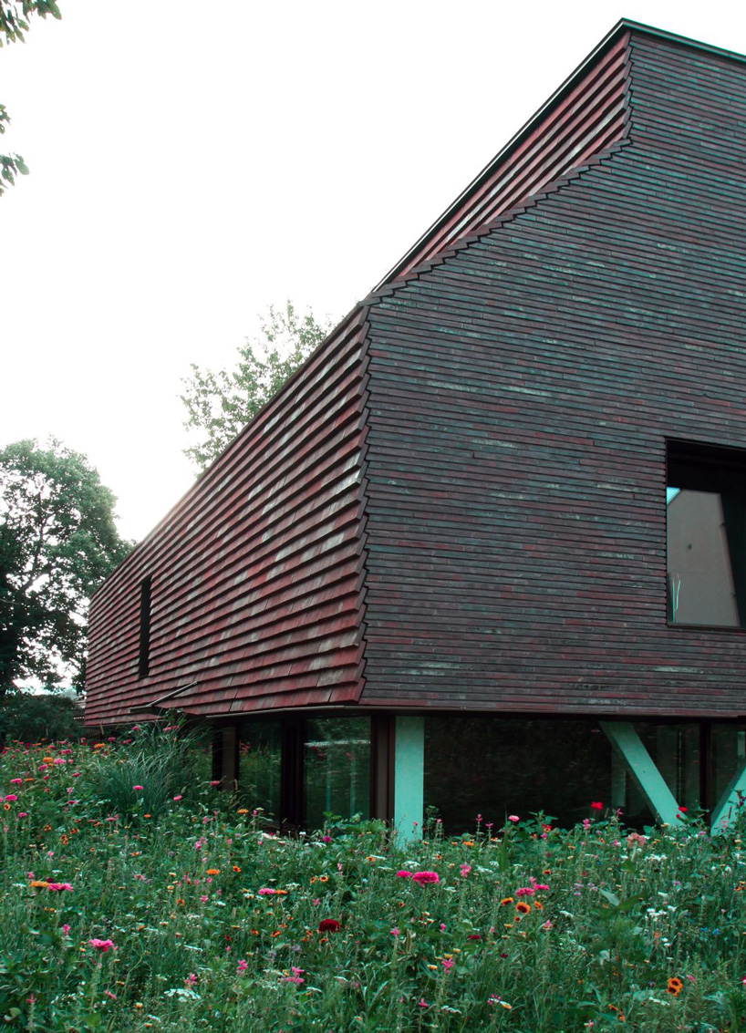 stocker lee architteti clads office building in switzerland in rust-red tiles + bricks