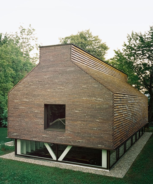 stocker lee architteti clads office building in switzerland in rust-red tiles + bricks