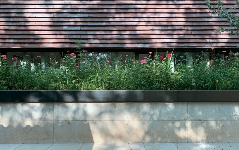 stocker lee architteti clads office building in switzerland in rust-red tiles + bricks