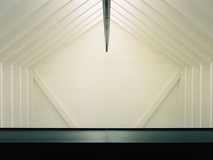 stocker lee architteti clads office building in switzerland in rust-red tiles + bricks