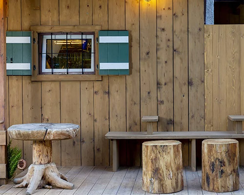 visual display redesigns traditional hut into modern dining destination in italian mountains