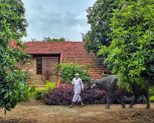 connected to the ground, the sloping roofs of these cottages in india bridge nature + architecture