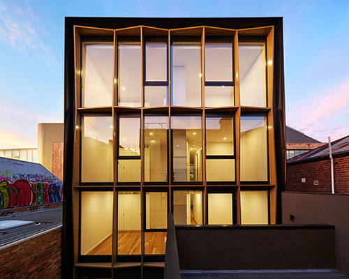 DROO frames burwood road apartment facade with faceted golden fins