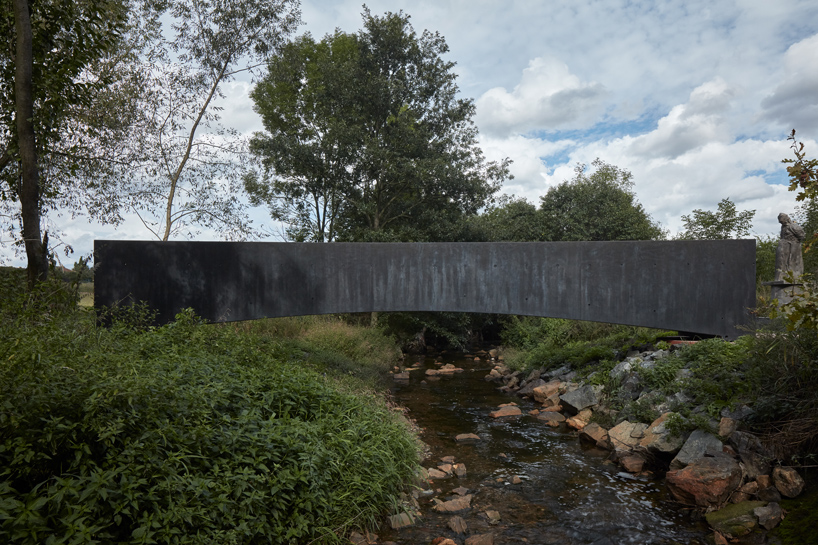 sleek concrete pedestrian bridge spans the vltava river in prague