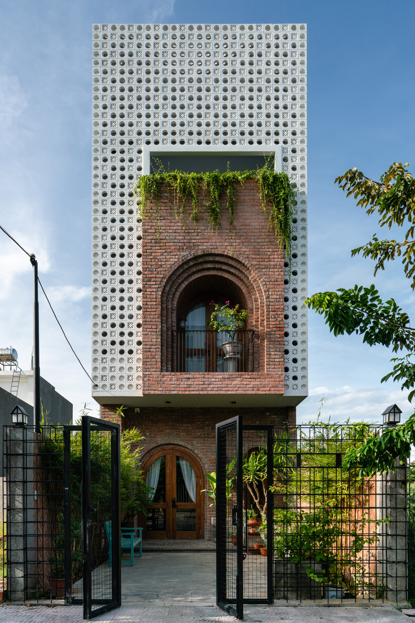 cội design inserts arched brick balcony to the perforated façade of