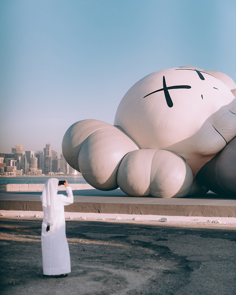 KAWS debuts inflatable sculpture on doha's dhow harbor overlooking the city skyline