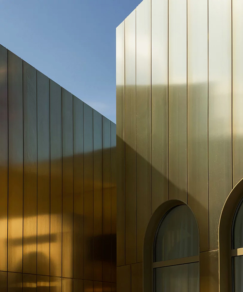 golden metal panels clad WALL's apartment complex showroom in moscow 