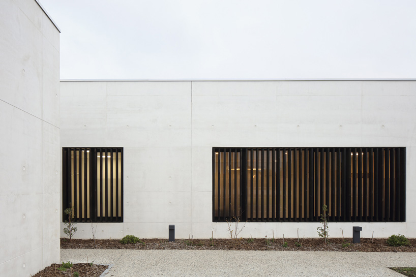 A6A combines white concrete + charred wood for les patios health center in france