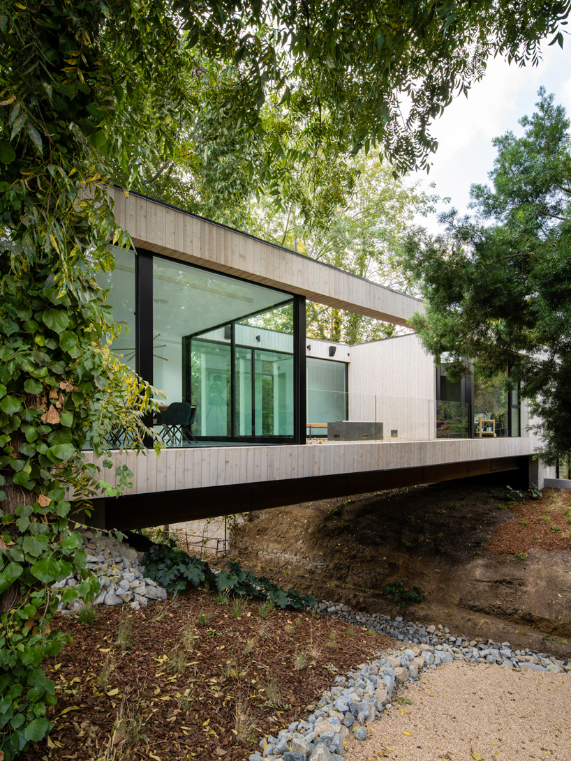 DBA's bridge house stretches 60 meters over a natural stream in los angeles