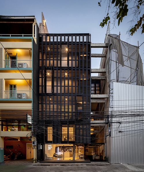IDIN architects completes pa prank hostel in bangkok with façade of black shutters