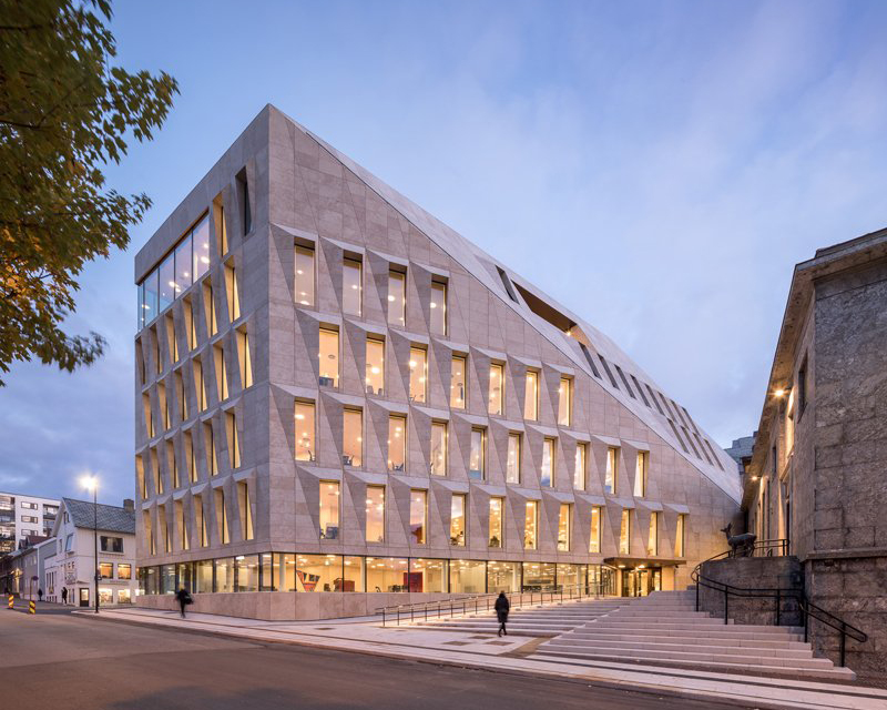 studio ALL's faceted stone facade plays with light on city hall in norway