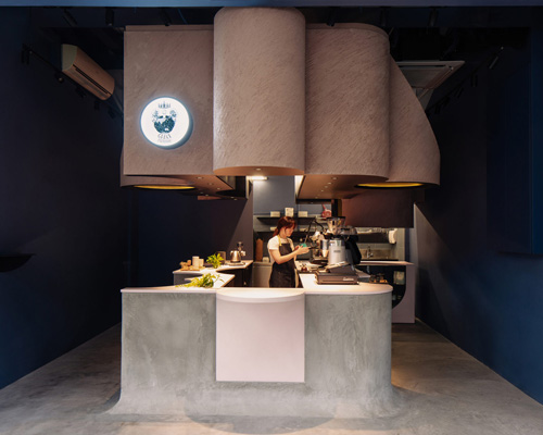 studio SKLIM's 'voids cafe' in singapore is carved out of a monolithic concrete block