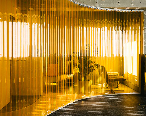 arii irie architects divides gym interiors with an orange vinyl strip curtain in tokyo