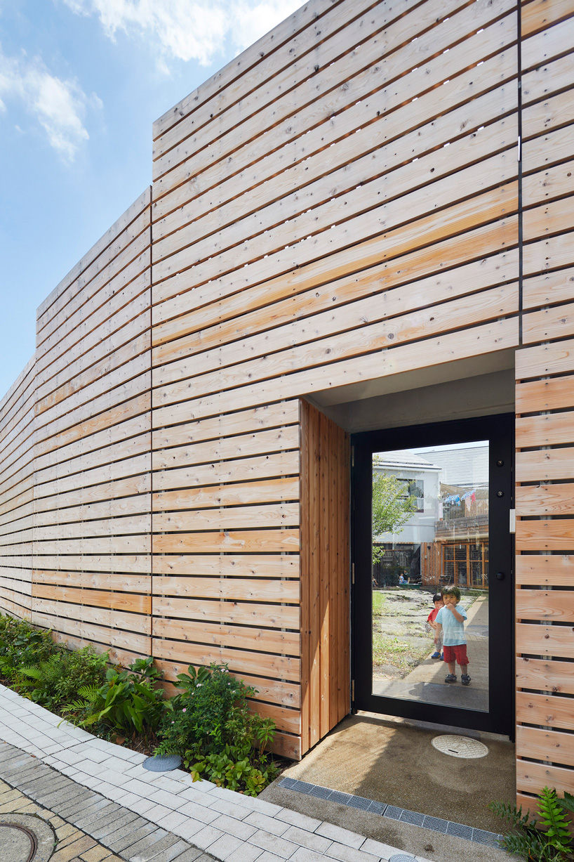 naf architect & design encloses 'small pond' nursery school in tokyo with curved wood façade
