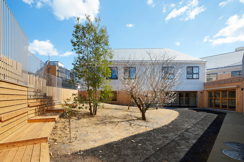 naf architect & design encloses 'small pond' nursery school in tokyo with curved wood façade