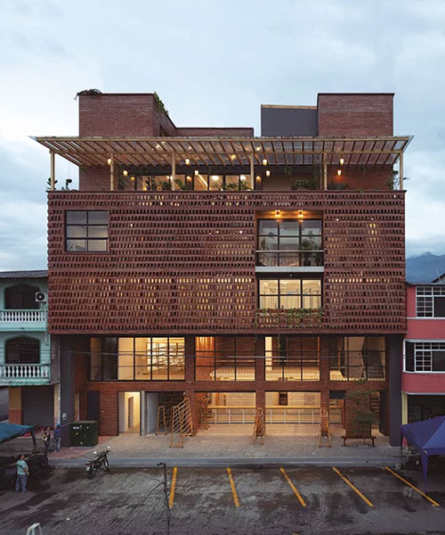 a permeable brick envelope clads natura futura's mixed-use building in ecuador