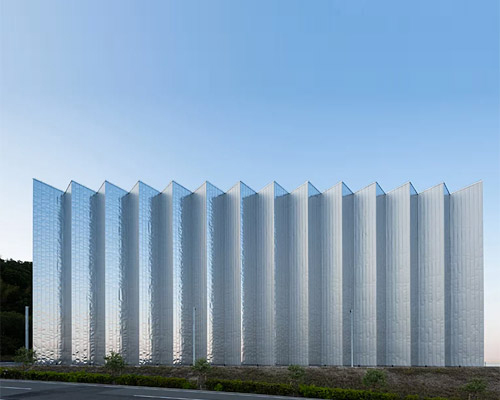 a reflective zig-zag façade clads OHArchitecture's factory in awaji, japan