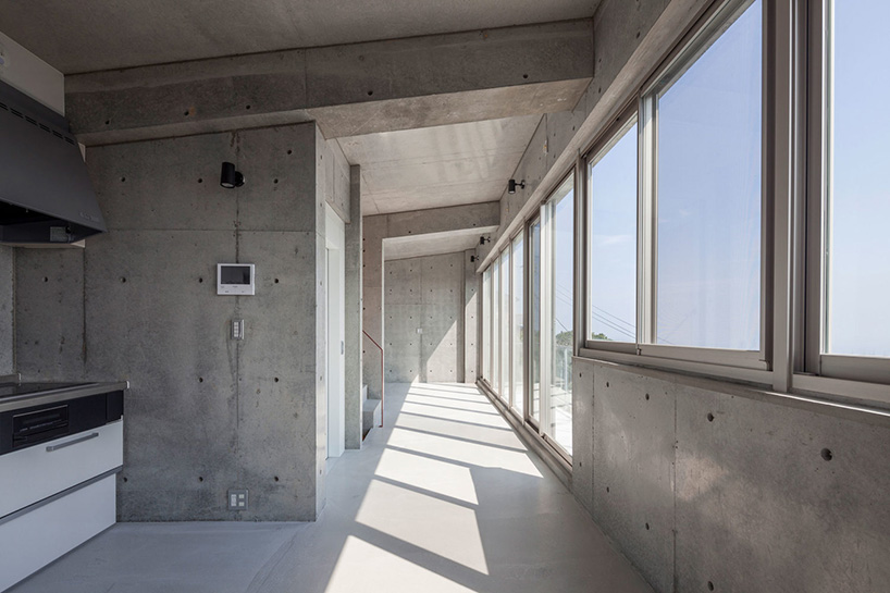 ashida architects sets concrete atami tower house on a steep slope in japan