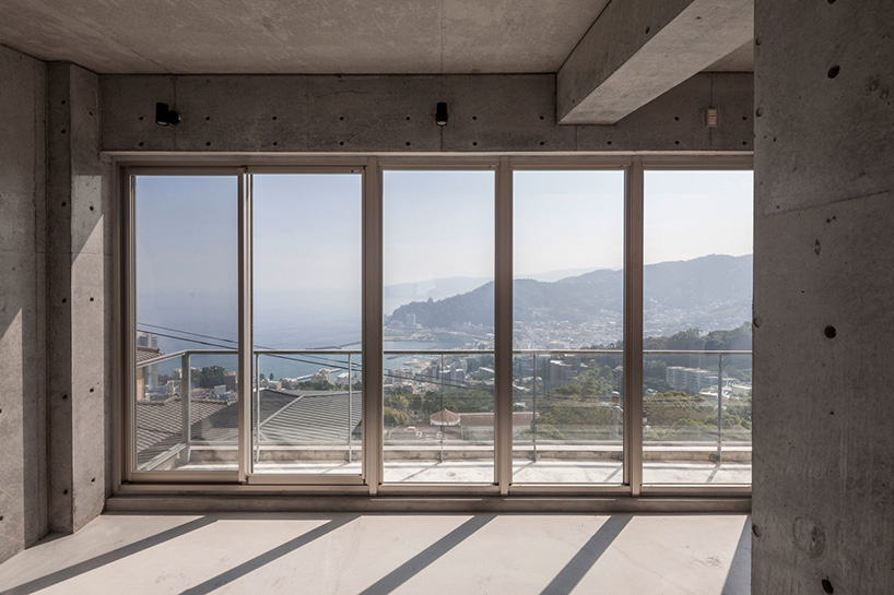 ashida architects sets concrete atami tower house on a steep slope in japan