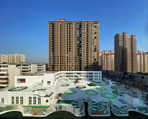 unarchitecte builds an artificial hillock into the lingbao children’s center in china