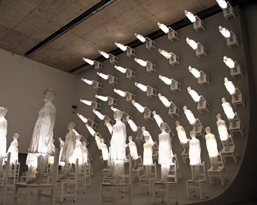 illuminated figures scale a ten-meter high wall in ataraxia by eugenio cuttica