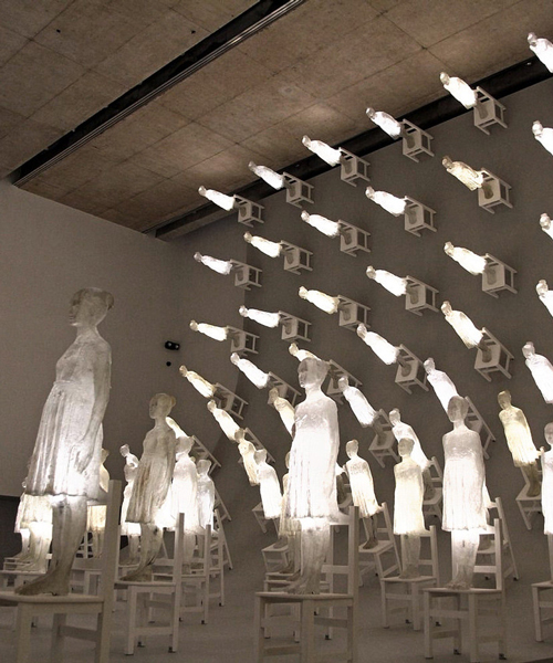 illuminated figures scale a ten-meter high wall in ataraxia by eugenio cuttica