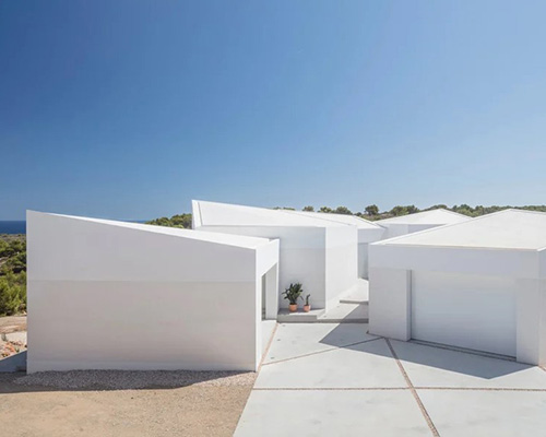 nomo studio lifts white polyhedral volumes above spanish landscape