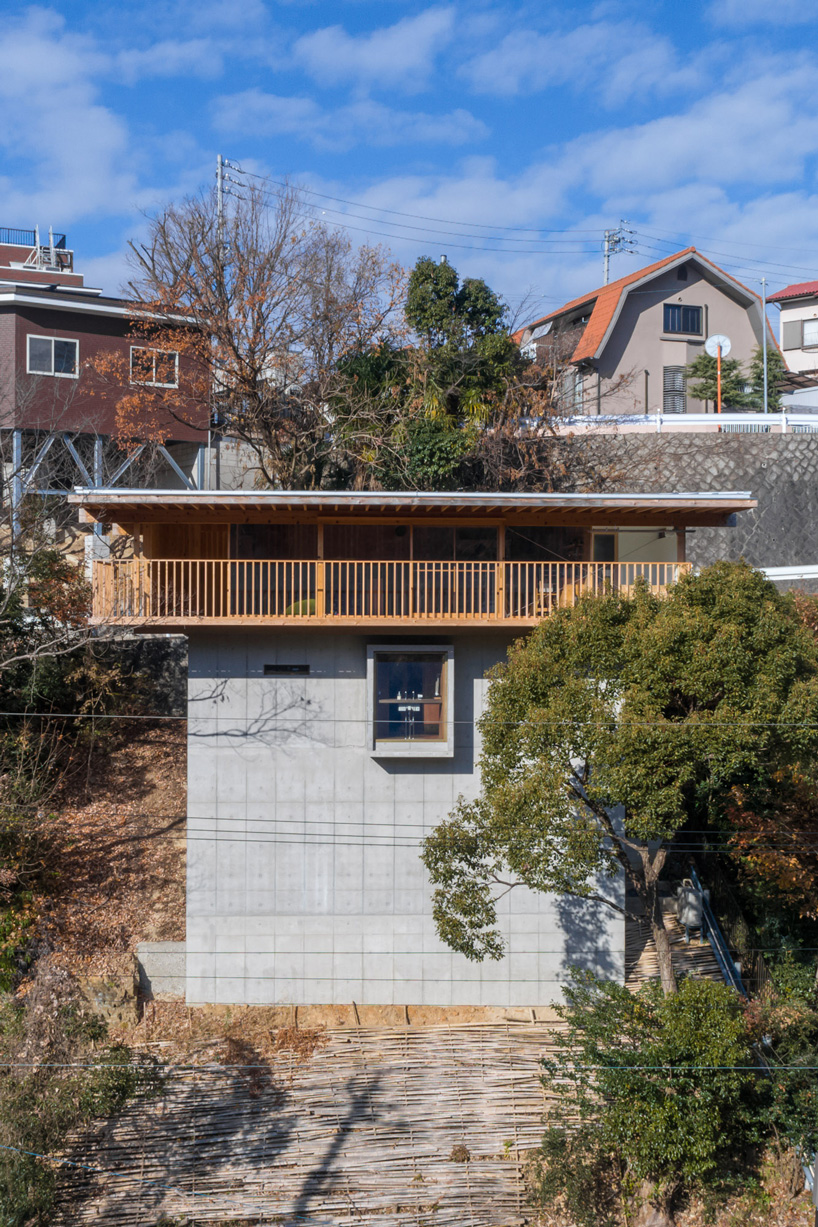 tomoaki uno architects places concrete + wood residence on steep slope in japan