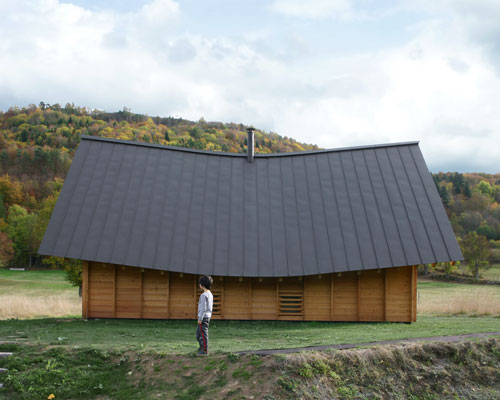 a curved roof tops this wooden house designed by arba in rural france